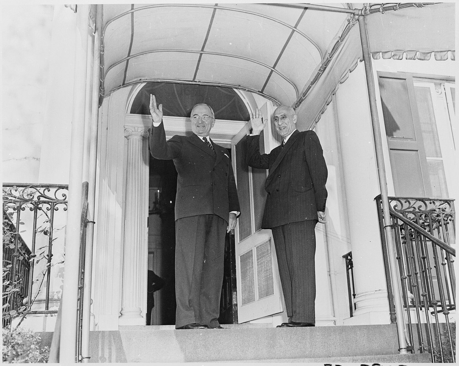 President Harry Truman and Prime Minister Mohammad Mosaddegh waving from a doorway