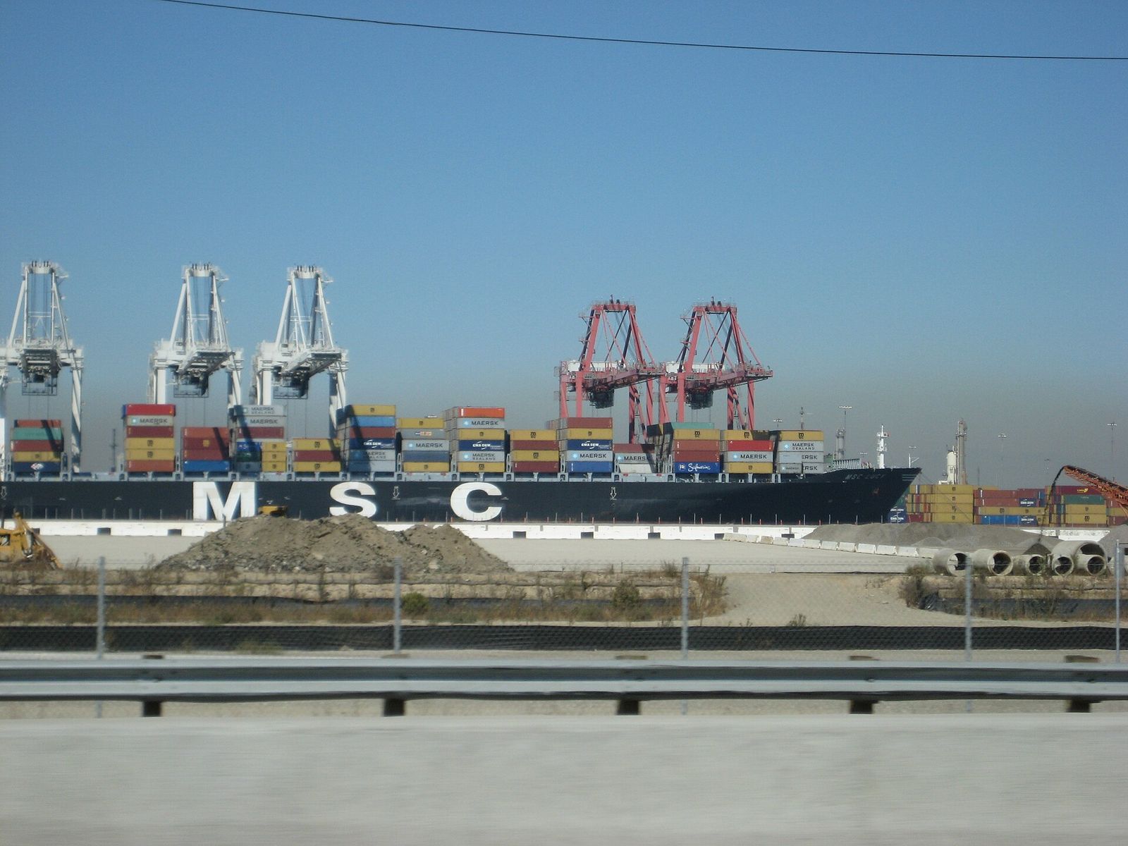 A container ship being loaded by cranes at the port of Long Beach, California