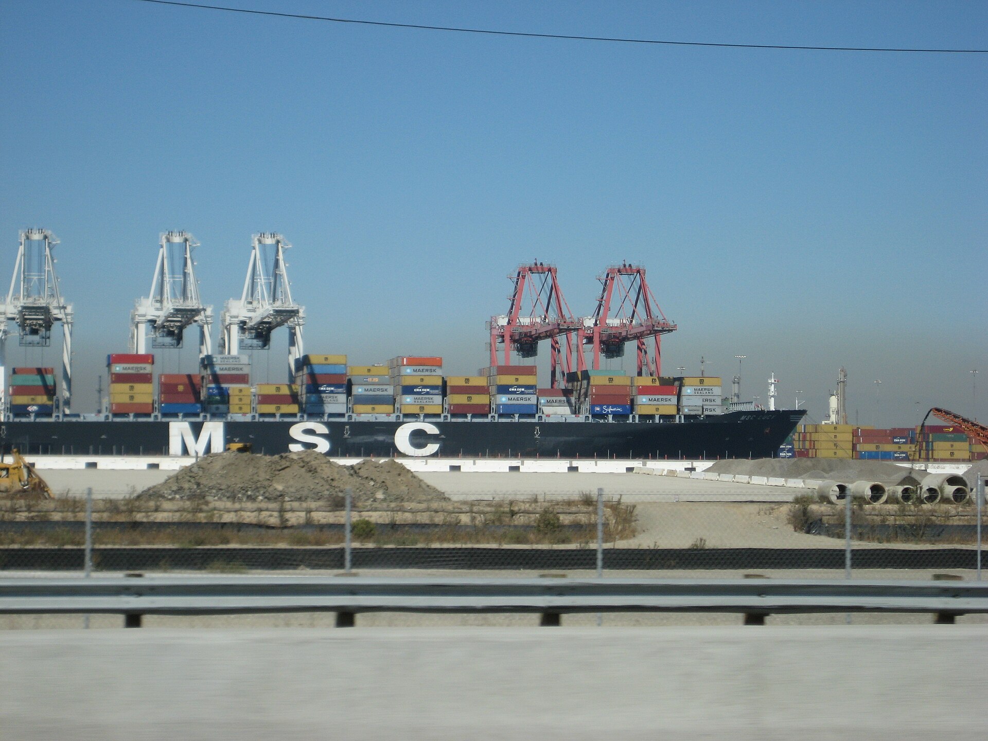 A container ship being loaded by cranes at the port of Long Beach, California