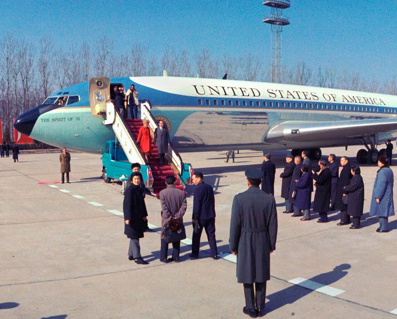 President Richard Nixon and Pat Nixon walking down the steps of Air Force One on arrival in China